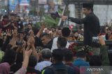 Presiden ketujuh RI Joko Widodo membagikan kaos ke warga saat melintas di jalan Colomadu, Karanganyar, Jawa Tengah, Minggu (20/10/2024). Joko Widodo resmi purna tugas dari Presiden Indonesia dan kembali pulang ke Solo. ANTARA FOTO/Aloysius Jarot Nugroho/Spt/gp