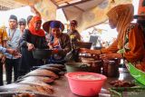 Calon Gubernur Jawa Timur nomor urut dua Khofifah Indar Parawansa (kiri) membantu pedagang ikan di Tempat Pelelangan Ikan muncar Banyuwangi, Jawa Timur, Senin (21/10/2024). Pada kampanyenya di Banyuwangi Khofifah mendatangi masyarakat nelayan untuk menyerap aspirasi dan menyampaikan visi dan misi dalam mewujudkan kesejahteraan nelayan. ANTARA Jatim/Budi Candra Setya/mas.