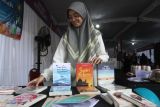 Santri menata buku yang dijual dalam Halal Market Day di jalan Gajahmada, Malang, Jawa Timur, Selasa (22/10/2024). Kegiatan pameran dan bazar tersebut diadakan dalam rangka Hari Santri Nasional dan menampilkan ratusan produk Unit Usaha Mikro Kecil Menengah (UMKM) yang didirikan para santri dan pondok pesantren. Antara Jatim/Ari Bowo Sucipto/um