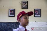 Pelajar berdiri di depan foto Presiden Prabowo Subianto dan Wakil Presiden Gibran Rakabuming Raka di salah satu ruang kelas di SDN Sukamaju 2, Kota Cimahi, Jawa Barat, Senin (21/10/2024). Prabowo Subianto dan Gibran Rakabuming Raka dilantik sebagai Presiden dan Wakil Presiden Republik Indonesia untuk masa bakti 2024-2029. ANTARA FOTO/Abdan Syakura/agr
