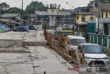 Kendaraan melintas di samping proyek Jalan Layang Nurtanio di Bandung, Jawa Barat, Senin (21/10/2024). Balai Besar Pelaksanaan Jalan Nasional (BBPJN) DKI Jakarta-Jawa Barat, Kementerian PUPR menyatakan proyek pembangunan Jalan Layang Nurtanio sepanjang 550 meter tersebut terkendala pembebasan lahan yang dapat mengakibatkan pengerjaan tidak sesuai dengan target. ANTARA FOTO/Raisan Al Farisi/agr