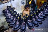 Pekerja menyelesaikan produksi sepatu di Sentra Produksi Sepatu Cibaduyut, Bandung, Jawa Barat, Selasa (22/10/2024). Kementerian Perindustrian mencatat hingga triwulan II-2024 kinerja industri alas kaki nasional mampu tumbuh sebesar 3,92 persen dibanding tahun yang lalu pada periode yang sama. ANTARA FOTO/Raisan Al Farisi/agr