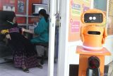 Pasien menerima layanan tes darah di laboratorium yang dilengkapi dengan teknologi robot di Puskesmas Dinoyo, Malang, Jawa Timur, Kamis (24/10/2024). Teknologi robotik Artificial Intelegence (AI) yang diberi nama Bytorium tersebut selain terintegrasi ke pusat data pasien juga dilengkapi dengan fitur komunikasi dua arah sehingga memudahan dan mempersingkat waktu layanan laboratorium antara lain tes darah serta kolesterol. ANTARA Jatim/Ari Bowo Sucipto/mas.