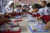 Pelajar menyantap makanan saat program makan bergizi gratis di SDN 3 Cipatat, Kabupaten Bandung Barat, Jawa Barat, Kamis (24/10/2024). Polres Cimahi bersama Kodim 0609 Cimahi menggelar program makan bergizi gratis sebagai upaya mewujudkan kesehatan anak melalui asupan makanan bergizi sesuai standar kesehatan nasional serta bentuk dukungan terhadap program prioritas atau Program Hasil Terbaik Cepat (PHTC) pemerintahan Prabowo Subianto-Gibran Rakabuming Raka. ANTARA FOTO/Abdan Syakura/agr
