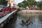 Tiga anggota TNI memungut sampah dari perahu karet saat kerja bakti massal di Sungai Kalimas, Surabaya, Jawa Timur, Kamis (24/10/2024). Kegiatan bersih-bersih sungai dari sampah yang bertujuan untuk mengantisipasi bencana hidrometeorologi saat musim hujan itu diikuti oleh sekitar 4.000 orang dari TNI, Polri, Organisasi Perangkat Daerah (OPD) Pemkot Surabaya, pelajar dan masyarakat umum. ANTARA Jatim/Didik Suhartono/mas.