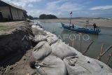 Nelayan dengan perahunya melintas di dekat bangunan yang terdampak abrasi di pantai Pekik Nyaring, Kabupaten Bengkulu Tengah, Bengkulu, Kamis (24/10/2024). Berdasarkan data BPBD Bengkulu Tengah, abrasi yang terjadi di wilayah tersebut menyebabkan dua rumah terbawa arus gelombang dan 20 pohon cemara tumbang serta tiga rumah lainnya terancam tergerus. ANTARA FOTO/Muhammad Izfaldi/tom.