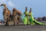 Model memperagakan gaun pengantin khas Banyuwangi di Pantai Marina Boom Banyuwangi, Jawa Timur, Sabtu (26/10/2024). Peragaan gaun pengantin yang masuk dalam rangkaian Festival Gandrung Sewu tersebut sebagai upaya mengenalkan keagaman pakaian adat yang biasa dikenakan pengantin suku Osing. Antara Jatim/Budi Candra Setya/um