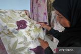 Seorang calon pembeli melihat motif kain batik berbahan alami (ecoprint) di industri rumahan Ani Ecoprint, Kota Sabang, Aceh, Senin (28/10/2024). Kain ecoprint berbasis pewarna alami dari daun tersebut dijadikan pakaian, pasmina, tas, topi, mukena, dan kerudung yang dijual secara langsung maupun daring ke konsumen domestik hingga mancanegara dengan harga jual mulai Rp65.000 - Rp500.000 per unit tergantung jenis produk. ANTAR FOTO/Khalis Surry