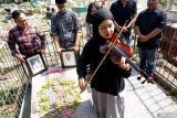 Sejumlah pemuda penggiat seni dan budaya melaakukan ritual doa sambil memainkan biola dengan instrumen lagu kebangsaan Indonesia Raya di pusara makam Willem Mauritius (WM) Van Eldik, guru musik pahlawan nasional WR Supratman di TPU Ngujang, Tulungagung, Jawa Timur, Senin (28/10/2024). Aksi tabur bunga dan doa bersama di atas makam itu mereka gelar dalam rangka memperingati Hari Sumpah Pemuda sekaligus menghormati jasa seorang vguru musik kelahiran Belanda yang berjasa atas 