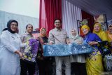 Menteri Kehutanan Raja Juli Antoni (kedua kiri) dan Wakil Menteri Kehutann Sulaiman Umar (keempat kanan) didampingi PJ Bupati Kabupaten Lumajang Indah Wahyuni (kiri) memperlihatkan produk batik saat kunjungannya di Lumajang, Jawa Timur, Rabu (30/10/2024). Kunjungan tersebut untuk meninjau kolaborasi pihak terkait dalam mendorong percepatan pengelolaan perhutanan sosial yang dikemas dalam konsep pengembangan wilayah terpadu berbasis perhutanan sosial atau integrated Area Development (IAD). Antara Jatim/Irfan Sumanjaya/um