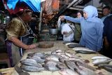 Calon Gubernur Jawa Timur nomor urut 2 Khofifah Indar Parawansa (kanan) membeli ikan bandeng di salah satu lapak pedagang saat berkampanye di Pasar Pacar Keling, Surabaya, Jawa Timur, Rabu (30/10/2024). Dalam kampanye tersebut Khofifah menyapa para pedagang untuk menyerap aspirasi mereka, membeli dagangan para pedagang serta menggelar layanan pemeriksaan kesehatan secara gratis. ANTARA Jatim/Moch Asim.