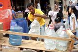 Warga mengambil air bersih dari bak penampungan hasil bantuan  Keluarga Alumni Universitas Jember (KauJe) di Desa Sumberjo, Kecamatan Durenan, Trenggalek, Jawa Timur, Minggu (3/11/2024). Ribuan liter air bersih disalurkan bertahap KauJe Korda Trenggalek di 12 desa empat kecamatan terdampak kekeringan untuk meringankan beban penderitaan masyarakat yang mengalami krisis air bersih sejak beberapa bulan terakhir. Antara Jatim/Destyan Sujarwoko/um