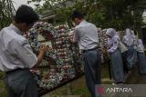 Siswa dan siswi menata botol plastik yang diisi dengan limbah anorganik atau ecobrick sebagai dekorasi sekolah di halaman SMKN 2 Pandeglang, Banten, Senin (4/11/2024). Sekolah tersebut memanfaatkan sampah plastik yang dikumpulkan dari para siswa untuk dijadikan beragam bentuk kerajinan dan dekorasi kreatif sebagai upaya mengurangi limbah plastik sekaligus menumbuhkan kreativitas siswa. ANTARA FOTO/Angga Budhiyanto/gp