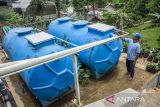 Peternak memeriksa tabung biodigester di peternakan sapi Babakan Ampera, Lembang, Kabupaten Bandung Barat, Jawa Barat, Senin (4/11/2024). Peternakan tersebut dalam seharinya mampu mengolah 250 kilogram kotoran hewan (kohe) menggunakan teknologi biodigester untuk dijadikan biogas yang digunakan sebagai pengganti alternatif gas elpiji dan pupuk organik untuk membantu petani lokal. ANTARA FOTO/Abdan Syakura/agr