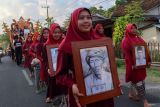 Sejumlah warga membawa foto tokoh adat Kemiren dari masa ke masa pada pawai budaya di Desa Wisata Adat Osing Kemiren, Banyuwangi, Jawa Timur, Selasa (5/11/2024). Arak-arakan yang melibatkan warga dan sejumlah tokoh pelestari Kebudayaan suku Osing tersebut merupakan rangkaian Festival Ngopi Sepuluh Ewu (sepuluh ribu kopi) yang digelar pada 5-6 November untuk memperingati Hari Jadi ke-167 Desa Wisata Osing Kemiren. Antara Jatim/Budi Candra Setya/um