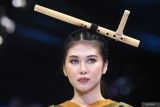 Model mengenakan aksesoris kepala berupa seruling saat memperagakan busana rancangan pelajar SMK 7 Malang berjudul Batungkau saat acara Malang Fashion Week (MFW) 2024 di Malang City Point, Jawa Timur, Jumat (8/11/2024). Pada hari kedua gelaran peragaan busana MFW tersebut ditampilkan ratusan karya fesyen berkonsep etnik berupa perpaduan corak kain tenun, batik, songket maupun lurik dari 45 desainer muda yang didominasi pelajar SMK. Antara Jatim/Ari Bowo Sucipto/um 