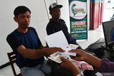 Petugas menyerahkan tanda bukti pelunasan kewajiban pembayaran Pajak Kendaraan Bermotor (PKB) kepada pembayar pajak di Badan Usaha Milik Desa (Bumdes) Margo Mulyo, Desa Bringinan, Jambon, Ponorogo, Jawa Timur, Jumat (8/11/2024). Bumdes Margo Mulyo memiliki sejumlah bidang usaha antara lain layanan pembayaran PKB, pajak daerah, pembayaran rekening PLN, PDAM, iuran BPJS, pulsa seluler pascabayar, minimarket, guna memudahkan masyarakat dalam mendapatkan layanan sekaligus meningkatkan kesejahteraan masyarakat desa. Antara Jatim/Siswowidodo/mas.