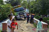 Warga berada di dekat truk yang menabrak jembatan di Kampung Katupang Teblongan, Cikeusal, Kabupaten Serang, Banten, Sabtu (9/11/2024). Tidak ada korban Jiwa dalam kecelakaan tersebut namun perjalanan kereta rute Rangkasbitung-Merak sempat terganggu. ANTARA FOTO/Putra M. Akbar/gp