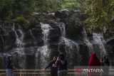 Sejumlah wisatawan berfoto di Curug Goong, Mandalawangi, Kabupaten Pandeglang, Banten, Sabtu (9/11/2024). Menteri Pariwisata Widiyanti Putri Wardhana telah menyusun empat program prioritas sebagai komitmen untuk melanjutkan upaya pengembangan pariwisata Indonesia diantaranya mendengar aspirasi dari pemangku kepentingan terkait transformasi pariwisata, memulai inisiatif Tourism 5.0 yang memanfaatkan teknologi digital dan kecerdasan buatan (AI) dalam pemasaran pariwisata, berencana menggunakan Indonesia Quality Tourism Fund untuk mendiversifikasi atraksi wisata nasional, serta berfokus pada peningkatan kualitas sumber daya manusia. ANTARA FOTO/Angga Budhiyanto/gp