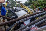 Warga memindahkan batang pohon yang tumbang menimpa kendaraan roda empat akibat angin kencang di Kota Cimahi, Jawa Barat, Sabtu (9/11/2024). Hujan deras disertai angin kencang mengakibatkan sejumlah pohon di beberapa wilayah di Kota Cimahi tumbang hingga menimpa kendaraan dan menyebabkan kemacetan lalu lintas. ANTARA FOTO/Abdan Syakura/agr