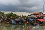 Kapal nelayan bersandar dengan latar belakang awan hitam yang menyelimuti langit di Karangantu, Kota Serang, Banten, Senin (11/11/2024). Badan Meteorologi Klimatologi dan Geofisika (BMKG) mengimbau masyarakat yang beraktivitas pada bidang pelayaran dan penerbangan untuk mewaspadai peningkatan intensitas hujan di sejumlah wilayah Indonesia akibat cuaca ekstrem. ANTARA FOTO/Putra M. Akbar/gp