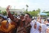 Menteri Usaha Mikro, Kecil, dan Menengah (UMKM) berfoto bersama sejumlah guru dan siswa usai upacara bendera di SMAN 3 di Pontianak, Kalimantan Barat, Senin (11/11/2024). Dalam kunjungan tersebut Maman Abdurrahman memberikan pidato berisi motivasi dan semangat untuk para siswa SMAN 3. Antara Kalbar/Victorya Fernando/Jhw