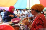 Calon Gubernur Jawa Timur nomor urut 2 Khofifah Indar Parawansa (kiri) membeli jajanan saat berkunjung ke Pasar Babaan, Surabaya, Jawa Timur, Senin (11/11/2024). Kunjungan tersebut guna menyerap aspirasi para pedagang dan membeli dagangan mereka sekaligus meminta dukungan atas pencalonannya sebagai calon Gubernur Jawa Timur. ANTARA Jatim/Moch Asim.