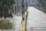 Sejumlah bocah bermain saat banjir di Perumahan Taman Mangu Indah, Jurangmangu Barat, Pondok Aren, Tangerang Selatan, Banten, Selasa (12/11/2024). Sebanyak 500 kepala keluarga terdampak banjir dan melumpuhkan akses Jalan Ceger Raya sejak Senin sore (11/11/2024) yang disebabkan proyek tanggul kali jebol tidak kuat menahan debit air hujan. ANTARA FOTO/Sulthony Hasanuddin/gp