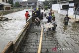 Sejumlah pekerja membuat penahan tanggul kali yang jebol saat banjir merendam Perumahan Taman Mangu Indah, Jurangmangu Barat, Pondok Aren, Tangerang Selatan, Banten, Selasa (12/11/2024). Pekerja membuat penahan tanggul kali sementara sepanjang 20 meter menggunakan papan, karung berisi pasir, dan rangka besi cor untuk mengurangi debit air yang masuk ke pemumikan warga. ANTARA FOTO/Sulthony Hasanuddin/gp