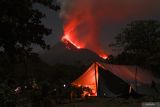 Aktivitas Gunung Lewotobi masih tinggi. Lava pijar dan kolom asap yang keluar dari kawah Gunung Lewotobi Laki-laki tampak dari lokasi pengungsian swadaya di perbukitan Desa Pululera, Wulanggitang, Kabupaten Flores Timur, Nusa Tenggara Timur, Senin (11/11/2024) malam. Pusat Vulkanologi dan Mitigasi Bencana Geologi (PVMBG) Badan Geologi Kementerian Energi dan Sumber Daya Mineral (ESDM) melaporkan hingga Selasa (13/11) pagi Gunung Lewotobi Laki-laki masih mengalami erupsi dengan ketinggian kolom abu setinggi 3.500-4.000 meter dan terus mengeluarkan lava ke arah barat laut. ANTARA FOTO/Aditya Pradana Putra/Spt.ANTARA FOTO/ADITYA PRADANA PUTRA (ANTARA FOTO/ADITYA PRADANA PUTRA)