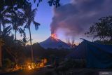 Aktivitas Gunung Lewotobi masih tinggi. Lava pijar dan kolom asap yang keluar dari kawah Gunung Lewotobi Laki-laki tampak dari lokasi pengungsian swadaya di perbukitan Desa Pululera, Wulanggitang, Kabupaten Flores Timur, Nusa Tenggara Timur, Selasa (12/11/2024). Pusat Vulkanologi dan Mitigasi Bencana Geologi (PVMBG) Badan Geologi Kementerian Energi dan Sumber Daya Mineral (ESDM) melaporkan hingga Selasa (13/11) pagi Gunung Lewotobi Laki-laki masih mengalami erupsi dengan ketinggian kolom abu setinggi 3.500-4.000 meter dan terus mengeluarkan lava ke arah barat laut. ANTARA FOTO/Aditya Pradana Putra/Spt.ANTARA FOTO/ADITYA PRADANA PUTRA (ANTARA FOTO/ADITYA PRADANA PUTRA)