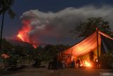 Aktivitas Gunung Lewotobi masih tinggi. Sejumlah pengungsi menyaksikan lava pijar dan kolom asap keluar dari kawah Gunung Lewotobi Laki-laki di lokasi pengungsian swadaya di perbukitan Desa Pululera, Wulanggitang, Kabupaten Flores Timur, Nusa Tenggara Timur, Senin (11/11/2024) malam. Pusat Vulkanologi dan Mitigasi Bencana Geologi (PVMBG) Badan Geologi Kementerian Energi dan Sumber Daya Mineral (ESDM) melaporkan hingga Selasa (13/11) pagi Gunung Lewotobi Laki-laki masih mengalami erupsi dengan ketinggian kolom abu setinggi 3.500-4.000 meter dan terus mengeluarkan lava ke arah barat laut. ANTARA FOTO/Aditya Pradana Putra/Spt.ANTARA FOTO/ADITYA PRADANA PUTRA (ANTARA FOTO/ADITYA PRADANA PUTRA)