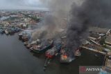 Foto udara petugas pemadam kebakaran berupaya memadamkan api ketika terjadi kebakaran kapal di Panjang Wetan, Kota Pekalongan, Jawa Tengah, Selasa (12/11/2024). Api yang menghanguskan sebanyak 13 kapal tersebut dapat dikendalikan setelah enam unit mobil pemadam kebakaran dikerahkan, penyebab kebakaran masih dalam proses penyelidikan. ANTARA FOTO/Harviyan Perdana Putra/wsj.