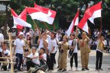 Sejumlah murid SD Sekolah Alam Insan Mulia (SAIM) mengikuti aksi teatrikal perobekan bendera di Surabaya, Jawa Timur, Selasa (12/11/2024). Kegiatan yang diikuti seluruh murid dan guru di sekolah tersebut sebagai pembelajaran sejarah sekaligus menanamkan nilai-nilai nasionalisme dan patriotisme. ANTARA JatimMoch Asim.