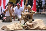 Sejumlah murid SD Sekolah Alam Insan Mulia (SAIM) mengikuti aksi teatrikal perobekan bendera di Surabaya, Jawa Timur, Selasa (12/11/2024). Kegiatan yang diikuti seluruh murid dan guru di sekolah tersebut sebagai pembelajaran sejarah sekaligus menanamkan nilai-nilai nasionalisme dan patriotisme. ANTARA Jatim/Moch Asim.