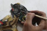 Perajin Febri Aminanto menyungging wayang kulit mini berbahan limbah kulit sapi di Merjosari, Malang, Malang, Jawa Timur, Kamis (14/11/2024). Febri memanfaatkan potongan limbah kulit sapi untuk dibuat berbagai karakter wayang berukuran tinggi 9 centimeter hingga 25 centimeter dengan jumlah produksi mencapai 30 buah per bulan yang kemudian dijual sebagai suvenir ke berbagai daerah dengan harga Rp10 ribu hingga Rp 20 ribu per buah menurut ukurannya. Antara Jatim/Ari Bowo Sucipto/um 