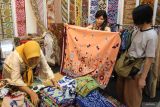 Pengunjung memilih kain batik saat Batik Fashion Fair di Surabaya, Jawa Timur, Kamis (14/11/2024). Pameran itu memajang berbagai busana batik yang merupakan produk unggulan pelaku usaha batik dari berbagi daerah di Jawa Timur dan berlangsung sampai 17 November 2024. Antara Jatim/Didik Suhartono/um