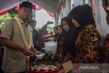 Menteri Desa dan Pembangunan Desa Tertinggal Yandri Susanto (kiri) mencicipi produk makanan buatan warga saat kunjungan kerja di Desa Kadugenep, Kecamatan Petir, Kabupaten Serang, Banten, Kamis (14/11/2024). Dalam kunjungannya tersebut Mendes PDT Yandri meresmikan Desa Kadugenep sebagai Kampung Ekonomi Kreatif Kerajinan Tas dan Kelakat Bambu, sekaligus meminta kepada para kepala desa untuk membentuk kedaulatan pangan dari desa dalam rangka mendukung program makan bergizi gratis. ANTARA FOTO/Angga Budhiyanto/gp