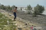 Seorang anak berjalan melewati sampah di Pantai Pasir Putih, Kasemen, Kota Serang, Banten, Kamis (14/11/2024). Pantai Pasir Putih yang merupakan salah satu destinasi wisata di wilayah utara pesisir Banten tersebut kondisinya tidak terawat karena adanya sampah dan kubangan lumpur. ANTARA FOTO/Putra M. Akbar/gp