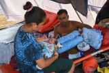 Pasangan pengungsi terdampak erupsi Gunung Lewotobi Laki-laki Paulus Rekatapun (kanan) dan Katarina Kire (kiri) menggendong anak mereka yang baru saja lahir di posko pengungsian Desa Kobasoma, Titehena, Kabupaten Flores Timur, NTT, Rabu (13/11/2024). Di tengah kondisi darurat akibat bencana erupsi Lewotobi mereka merawat putra mereka yang lahir secara normal pada Rabu dini hari. ANTARA FOTO/Aditya Pradana Putra/Spt.
