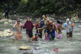 Sejumlah ibu menggendong anaknya menyeberangi sungai Ciujung di Desa Parakanbeusi, Lebak, Banten, Jumat (15/11/2024). Jembatan gantung yang menjadi akses utama penghubung Kecamatan Leuwidamar-Bojongmanik tersebut ambruk pada Kamis (14/11/2024) diduga akibat rusak termakan usia sehingga menyebabkan warga dan siswa terpaksa menyeberang sungai karena akses jalur alternatif yang jauh dengan menempuh jarak sekitar 20 kilometer. ANTARA FOTO/Muhammad Bagus Khoirunas/gp