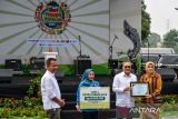 Menteri Koordinator Bidang Pangan Zulkifli Hasan (kedua kanan) didampingi PJ Gubernur Jawa Barat Bey Machmudin (kiri) memberikan bantuan dan penghargaan kepada perwakilan perangkat daerah saat melakukan kunjungan kerja di Bandung, Jawa Barat, Sabtu (16/11/2024). Dalam kunjungan kerjanya Menko Bidang Pangan berkesempatan untuk membuka kegiatan Hari Pangan Sedunia yang diadakan oleh Pemerintah Provinsi Jawa Barat serta meninjau program ketahanan pangan dari berbagai kota yang ada di Jawa Barat. ANTARA FOTO/Raisan Al Farisi/agr
