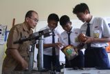 Siswa mempratekkan cara pembuatan briket kompos ekonomis atau brikomek kepada rekan seprofesinya di SMPN 30, Malang, Jawa Timur, Senin (18/11/2024). Inovasi briket berbahan campuran kompos daun kering dan arang yang dibuat Supriyadi tersebut dinilai memiliki biaya produksi lebih murah dibandingkan briket batu bara sehingga bisa menjadi solusi permasalahan sampah di sekitar sekolah sekaligus menjadi sarana edukasi bagi para siswa. Antara Jatim/Ari Bowo Sucipto/um