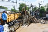 Petugas Badan Penanggulangan Bencana Daerah (BPBD) dan Dinas Pekerjaan Umum dan Penataan Ruang (PUPR) mengangkat sampah sungai yang menyangkut di jembatan akibat banjir di Kota Madiunn, Jawa Timur, Senin (18/11/2024). Sejumlah wilayah kelurahan dan desa di Kota dan Kabupaten Madiun terdampak banjir akibat hujan deras hingga sungai meluap yang menyebabkan sejumlah rumah, ruas jalan, sawah, dan dua gedung sekolah terendam sehingga murid diliburkan. Antara Jatim/Siswowidodo/um