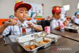 Siswa bersiap menyantap makanan bergizi gratis di SDN Sirahcai, Jatinangor, Kabupaten Sumedang, Jawa Barat, Senin (18/11/2024). Untuk mendukung Program Makan Bergizi Gratis yang direncanakan pemerintah pusat, Pemprov Jabar akan memanfaatkan bahan baku lokal yang dipasok dari 27 kabupaten/kota di wilayahnya. ANTARA FOTO/Raisan Al Farisi/agr
