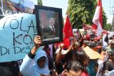 Sejumlah petani dari desa Satak membentangkan poster dan foto presiden saat unjuk rasa di depan Kantor Perum Perhutani, Kota Kediri Jawa Timur, Senin (18/11/2024). Aksi ratusan petani yang disertai dengan penutupan jalan tersebut guna menuntut kejelasan kepada Perhutani terkait hak garap lahan Hutan Produksi Daerah (HPD) Satak seluas 180 hektare.  ANTARA Jatim/Prasetia Fauzani/mas.