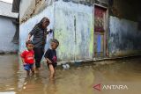 Warga berjalan melewati banjir rob di Desa Lontar, Tirtayasa, Kabupaten Serang, Banten, Senin (18/11/2024). Balai Besar Meteorologi Klimatologi dan Geofisika (BBMKG) Wilayah II Tangerang Selatan mengeluarkan peringatan dini terkait potensi banjir rob yang diperkirakan terjadi di wilayah pesisir Provinsi Banten pada 18-20 November 2024, yang menyebabkan peningkatan ketinggian air laut maksimum akibat fenomena supermoon pada 16 November lalu. ANTARA FOTO/Putra M. Akbar/spt/gp