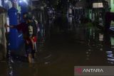 Seorang warga menggendong anak melewati genangan banjir di Rangkasbitung, Lebak, Banten, Rabu (20/11/2024). Hujan lebat yang terjadi selama tiga jam di daerah itu mengakibatkan banjir di sejumlah lokasi dengan ketinggian banjir mencapai sekitar 80 sentimeter. ANTARA FOTO/Muhammad Bagus Khoirunas/tom/gp