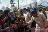 Menteri Pertanian Andi Amran Sulaiman (kanan) bersama Menteri Desa dan Pembangunan Desa Tertinggal Yandri Susanto (kedua kanan) menyapa warga saat menghadiri peresmian Gugus Tugas Polri mendukung ketahanan pangan di Gunung Kencana, Kabupaten Lebak, Banten, Rabu (20/11/2024). Dalam peresmian tersebut Polda Banten memberikan bantuan bibit jagung sebanyak 64.875 kilogram dengan lahan seluas 4.325 hektare yang akan dikerjakan oleh kelompok tani binaan di tiga kabupaten dan dua Lembaga Masyarakat Desa Hutan (LMDH) dalam rangka mendukung program swasembada pangan. ANTARA FOTO/Angga Budhiyanto/gp