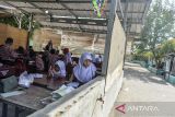 Sejumlah siswa mengikuti kegiatan belajar mengajar di SD Negeri Lontar 2, Tirtayasa, Kabupaten Serang, Banten, Rabu (20/11/2024). Pihak sekolah menuturkan rusaknya tiga ruang kelas di sekolah tersebut sejak tahun 2018 mengganggu proses belajar mengajar sehingga terpaksa memindahkan KBM ke ruangan lain.  ANTARA FOTO/Putra M. Akbar/rwa/gp